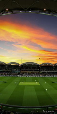 the sun is setting at an australian cricket stadium