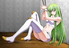 a woman with long green hair sitting on the floor next to a wall holding two sticks