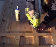 a person sanding down some wood with a power drill and glue bottle next to it