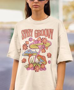 Stay Groovy is a perfect 70s inspired retro shirt for people who loves hippie groovy aesthetic and mushrooms. Add this 70s retro shirt to your Aesthetic Clothes collection! Also available on back print tshirts, sweatshirts and hoodies: Browse through my other awesome items here: http://thenims.etsy.com/ UNISEX TEES Gildan 5000™ (CUSTOMER FAVORITE) * 100% Cotton (fiber content may vary for different colors) * Medium fabric (5.3 oz/yd² (180 g/m * Classic fit * Tear away label * Runs true to size * 70s Shirt Design, Mushroom Shirt Design, Retro Graphic Tshirt, 70s Tshirt Design, Groovy Tshirt Design, Hippy Shirts, Indie Tshirt, 70s Tshirt, Groovy Clothing