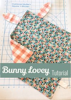 the bunny lovey quilt pattern is laying on top of a piece of fabric with scissors