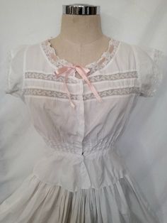 1900-10's edwardian corset cover,  blouse, with horizontal valenciennes lace inserts. Round neckline with lace trim and insert pink ribbon. Small cap sleeves with  lace trim. Nipped waist shaped with pleats on both sides and back, according the period silhouette, and a little peplum extension.  Front closure with hidden loops and small mother of pearl buttons. It fits a size S/M, depending on  body shape. Please check measures for accuracy. Bust 92cm/36.2" Waist 64cm/25.2" Heigth 44cm/17.3" Ther Victorian Lace Trim Top For Daywear, Cottagecore Lace Trim Blouse For Daywear, Cottagecore Blouse With Lace Trim For Daywear, Vintage White Victorian Dress With Lace Trim For Daywear, Fitted Vintage Blouse For Gatherings, Vintage Wedding Bodice With Historical Design, Daywear Victorian Dress With Lace Patchwork, Fitted Vintage Victorian Dress With Cancan, Fitted Vintage Victorian Dress With Attached Cancan