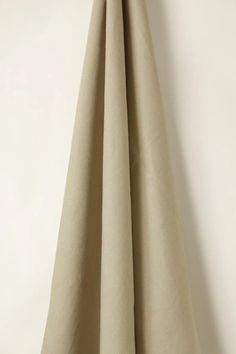 a beige curtain hanging on a white wall