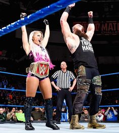 two women standing next to each other in a wrestling ring