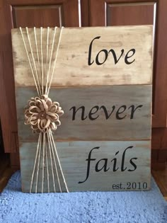 a wooden sign that says love never falls and has a flower on the front with words above it