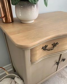 an old dresser with a potted plant on top