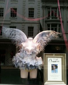 a display window with an angel statue and framed photograph