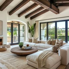 a living room with couches, coffee table and fireplace in the middle of it