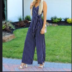 Never Worn Vici Jumpsuit In Navy Blue With White And Orange Strip Accents. Front Feature A Structured Wire V Detail With A Tie Front. Photo Of Model From Vici. Blue Casual Jumpsuits And Rompers For Date Night, Casual Blue Jumpsuits And Rompers For Date Night, Blue Jumpsuits And Rompers For Summer Date Night, Blue Jumpsuit For Date Night In Summer, Chic Navy Jumpsuits And Rompers For Summer, White And Orange, White Jumpsuit, Of Model, Model Photos