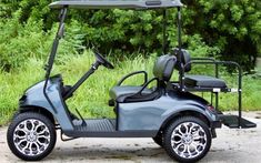 a blue golf cart parked in front of some trees