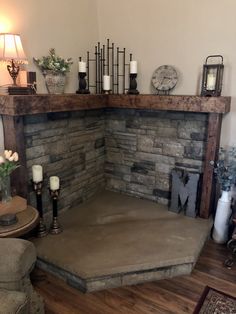 a corner fireplace with candles and flowers on the mantle