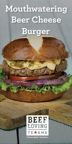 a cheeseburger with lettuce and onions on a cutting board