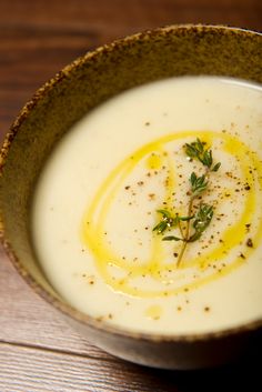 a close up of a bowl of soup on a table with parsley in it