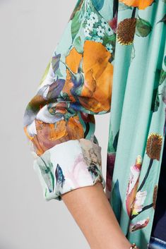 a close up of a woman's shirt with flowers on the sleeves and cuffs