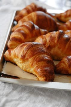 some croissants are laying on a tray