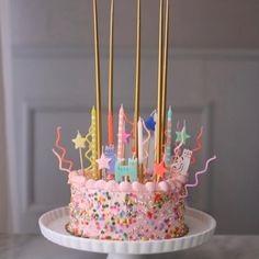 a birthday cake decorated with candles and confetti