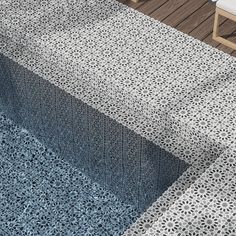 an outdoor area with blue and white rugs on the floor, chairs and table