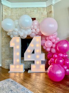 the number four is surrounded by balloons in front of a fire place with a fireplace