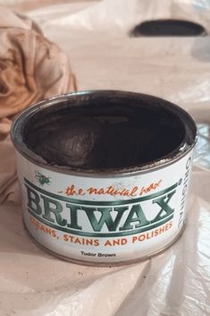 a can of brlwax sitting on top of a plastic bag next to a ball of brown paper