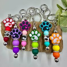 the key chain is decorated with different colored beads and dog paw prints on each bead