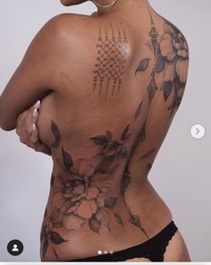 the back of a woman's body with tattoos on her upper and lower half