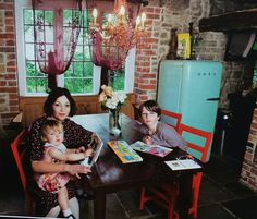 two women and a child are sitting at a table with books in front of them