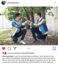 two men in blue and gold jackets are sitting on a bench with their hands together