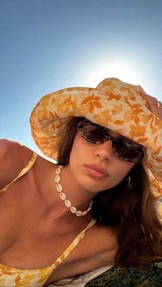 a beautiful woman wearing a yellow hat and sunglasses