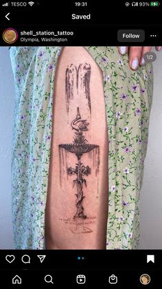 a person with a tattoo on their arm that has a cross and flowers around it