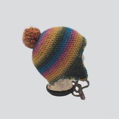 a multicolored knitted hat with a pom - pom on top