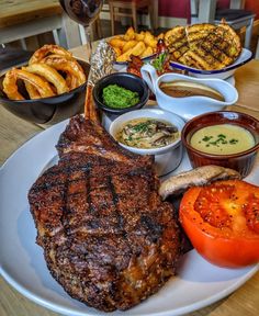 a plate with steak, fries and tomatoes on it