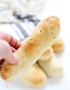 a person holding a piece of bread in their hand