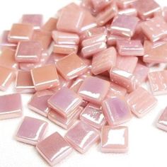 some pink and brown glass tiles on a white surface