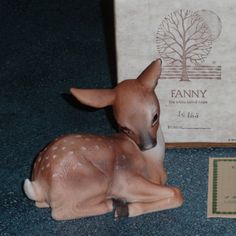 a small deer figurine sitting next to a box with an envelope on it