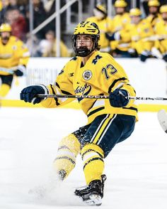 a hockey player in yellow and blue uniform on the ice