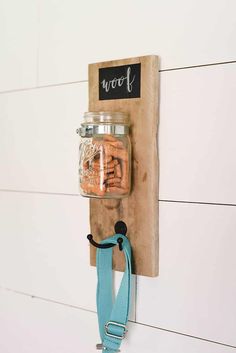 a mason jar hanging on a wall with a chalkboard attached to it and a blue ribbon