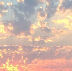 an airplane flying high in the sky at sunset with clouds and trees around it,