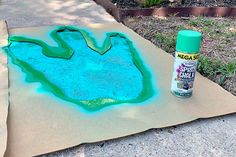 a piece of cardboard sitting on top of a sidewalk next to a bottle of glue