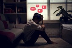 a woman sitting on the floor in front of a window with red speech bubbles above her head