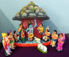 a group of figurines sitting next to each other on a purple tablecloth