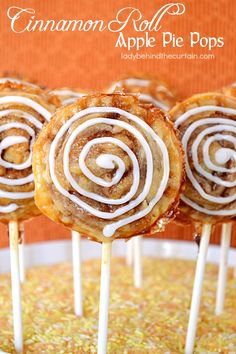 several desserts on sticks with icing sitting in a bowl