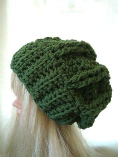 a woman with blonde hair wearing a green crochet hat