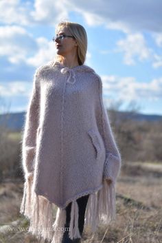 "Handknit soft and warm mohair poncho.Chunky style.Hooded.With openings for the arms. The poncho is one-size fitting any size. Length front center - 89cm / 35\" without the fringes length front center - 112cm / 44\" with fringes. Material : 3 strands 80% soft premium quality mohair. The poncho`s length measured from the neckline is 74cm / 29\" laid flat and 82cm / 32\" when put on or hanging. The fringes give additional length and reach the knees. The lady modeling is size Small chest - 88cm / 3 Handmade Oversized Winter Poncho, Winter Handmade Oversized Poncho, Handmade Winter Poncho, Handmade Cozy Winter Poncho, Cozy Handmade Winter Poncho, Hand-knitted Beige Poncho For Winter, Hand Knitted Beige Poncho For Winter, Hand Knit Poncho, Mohair Jumpers