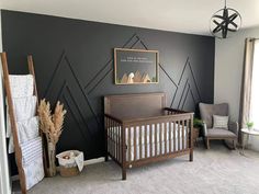 a baby's room decorated in black and white with mountains on the wall behind it