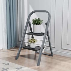 a small metal step stool with a potted plant on it next to a window