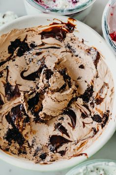 a bowl filled with ice cream sitting on top of a table next to other bowls