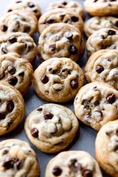 chocolate chip cookies are lined up on a baking sheet