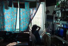 a woman sitting on a chair in front of a window