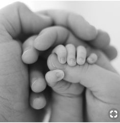 a hand holding a baby's finger with the words we're a family, we stick together