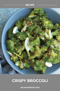 a blue bowl filled with broccoli on top of a table